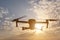 Black silhouette of a foldable drone flying in the sky.