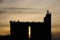 Black silhouette of a grain elevator at a bakery against a background of orange evening sunset. Installation of radio transmitters