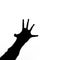 Black silhouette of human hand with spread fingers stretches like in horrors