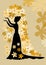Black silhouette of lady with bun in gown with siding. Lady with her arms folded against on golden background is