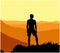 Black silhouette of man standing on the top of the hill, enjoying beautiful sunset, orange background.