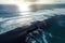 Black silhouette of an oil tanker in the distance, pumping more oil.Aerial view of a vast oil spill enveloping the ocean,