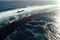 Black silhouette of an oil tanker in the distance, pumping more oil.Aerial view of a vast oil spill enveloping the ocean,