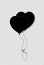 Black silhouette of pair bounded heart shaped helium balloons