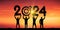Black silhouette people holding numbers 2024 with colorful dramatic sky at sunset. Hit the target. Concept for success in the