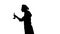 Black silhouette of professional cook tasting food from a ladle.