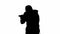 Black silhouette of thief on isolated white background. Male robber in hoodie and balaclava walking with a gun in his