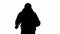 Black silhouette of thief on isolated white background. A male robber in a hoodie and balaclava walks with a knife in