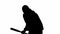 Black silhouette of thief on isolated white background. A male robber in hoodie and balaclava walks with a wooden club