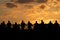 Black silhouettes of fishermen standing on a bridge