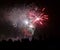 black silhouettes of people watching the show of fireworks