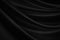 Black silk satin. Soft, wavy folds. Fabric surface. Luxurious black white background