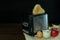 Black and silver electric micro oven with toast, fresh eggs, red apple and glass of milk on brown wooden and black background,