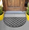 Black Silver Semi-Circle Round Rubber Doormat outside home with yellow flowers and leaves