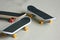 Black skateboards on gray striped surface. Skate board group of three with shadows and partly soft focus. Perspective view of