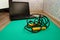 Black skipping rope and laptop on the floor at the edge of a sports mat. Sports at home remotely.