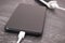 Black smartphone with connected plug of external powerbank. Mobile phone charging