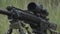 Black sniper rifle is on the ground in the grass. airsoft guns
