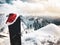 Black Snowboard with christmas hat stand in snow beautiful white caucasus mountains in Gudauri ski resort top viewpoint in winter