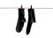 Black socks hang drying on the clothesline with clothespins. Closeup. Isolated on a white background