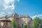 Black solar panels on shingle roofing of two story suburban residential house under sunny cloud blue sky in Flower Mound, Texas,