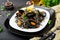 Black spaghetti. Black seafood pasta with mussels over black background