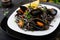Black spaghetti. Black seafood pasta with mussels over black background