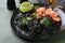 Black spaghetti pasta shrimp on black plate on dark concrete table background. Squid ink pasta with prawns. Pasta seafood. Top