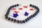 Black spherical beads with a white stripe, purple flowers and red flower petals