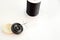Black spool of thread, needle, and black and white buttons