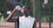 Black sportsman drinking from bottle after basketball training