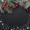 Black square stone background, with fir branches adorned with red balls. Biscuits of various shapes