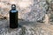 Black steel flask for water on a natural stone background.