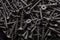 Black steel self-tapping screws used in handicrafts background texture