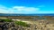 Black stone beach on coast or shore of the Atlantic ocean with waves and blue sky and windmills in Canary island, Spain