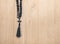 Black stone christianity beads with cross on wooden desk