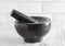 Black Stone Mortar and Pestle on a Marble Countertop