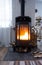 Black stove, fireplace in interior of house in loft style. Alternative eco-friendly heating, warm cozy room at home, burning wood