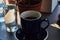 Black and strong morning coffee in blue mugs and green plants in pots.