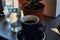 Black and strong morning coffee in blue mugs and green plants in pots.