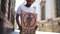 A black student in a white T-shirt stands in the middle of a city street. African American man holding a placard with