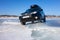 Black Subaru Forester at frozen lake ice