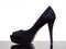 Black suede court shoe with reflection and isolated on white behind. Woman`s footwear with ridiculously high heel.