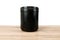 Black supplement tub on a wood patterned background