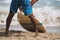 A black surfer in shorts is getting ready to go into the ocean