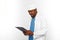 Black surgeon doctor bearded man in white coat and cap looks to medical chart on clipboard on white