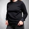 Black sweatshirt jacket with sleeves dressed on a girl on a gray background. Vertical orientation