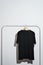 Black t-shirt displayed on clothes rack