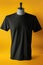 A black t-shirt on a mannequin on a yellow background