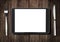 Black tablet pc on dark wooden table with fork and